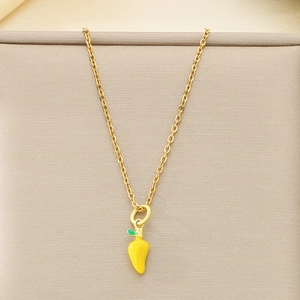 Vue macro d'un collier doré avec un pendentif piment en émail jaune et détails verts