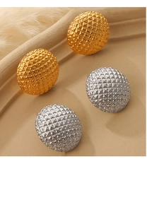 Close-up of elegant gold and silver oval earrings with refined diamond-pattern texture