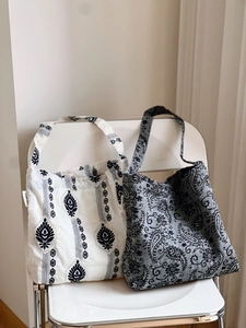Détail de sacs fourre-tout en toile brodée avec motifs ethniques et imprimés cachemire