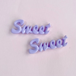 Détail de breloques 'Sweet' en résine violette pour loisirs créatifs et accessoires cheveux