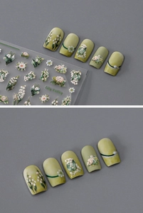 Close-up of 3D embossed lily of the valley nail stickers with green floral patterns