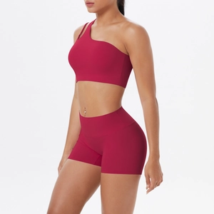 Detail view of dark red one-shoulder sports bra and high-waisted shorts set