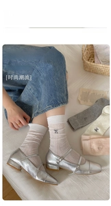 Close-up of bow embroidery detail on thin breathable mesh socks for women in soft colors