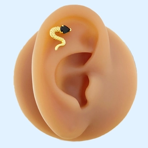 Detailed view of a gold snake-shaped ear bone stud with a black pear-shaped gemstone