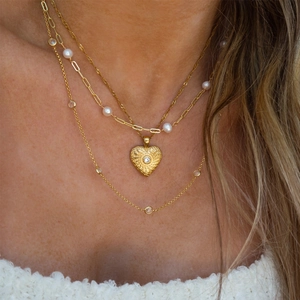 Detailed layered necklace set featuring a heart pendant, pearls, and crystals in 18K gold