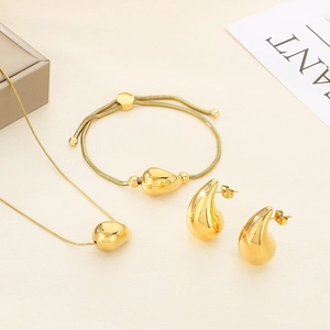 Flat lay of 18K gold plated teardrop jewelry set with necklace, bracelet and earrings