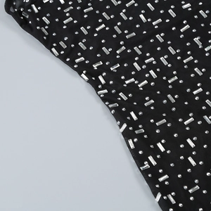Macro detail of black mesh fabric featuring intricate silver sequins and rhinestone patterns