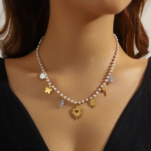 Minimalistische Perlenkette mit goldenen Herzanhängern und Kleeblatt am Model