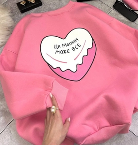 Détail du sweat rose oversize avec imprimé cœur et lettrage en langue slave