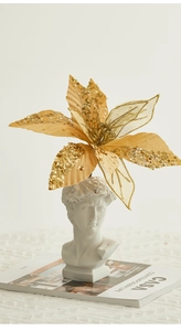 Champagne gold Christmas flower with sequins placed on a modern David bust statue