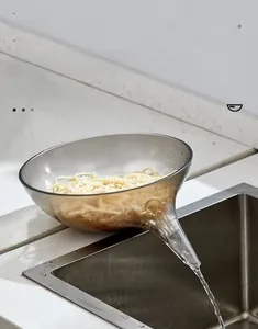 Detail showing the gray transparent drain bowl pouring water from long spout into sink