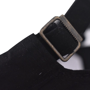Close-up of vintage bronze metal buckle and adjustable black strap on the military cap