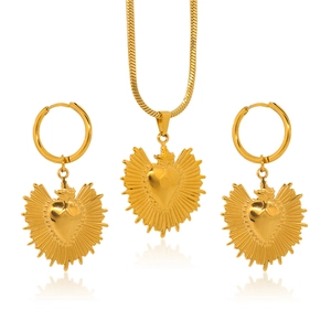Parure de bijoux cœur dorée avec collier et boucles d'oreilles sur fond blanc