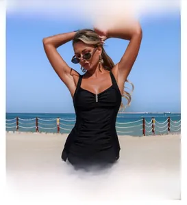 Tankini deux pièces noir avec haut plissé et short de bain sur une plage ensoleillée
