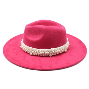 Detail of fuchsia wool fedora hat featuring a wide brim and decorative pearl band