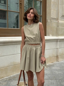 Two-piece morandi green set featuring sleeveless crop top and high-waisted pleated mini skirt