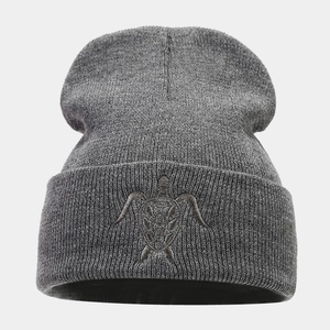Detailed view of turtle embroidery on grey knitted beanie with ribbed texture