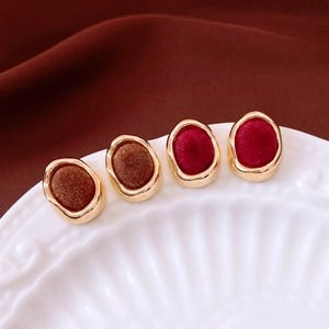 Detailed close-up of vintage metal earrings with elegant velvet flocking in red and brown