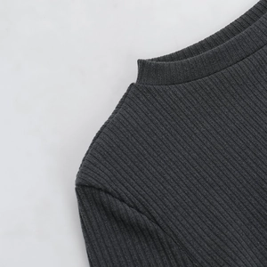 Detailed macro view of dark grey ribbed knit fabric on the elegant shoulder and neckline area