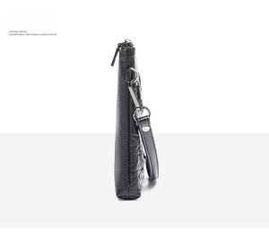 Slim side view of black pebble grain leather clutch with wristlet strap and silver buckle