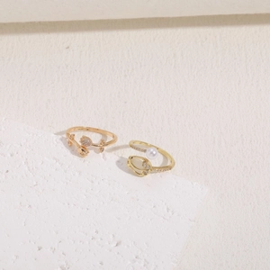 Elegant tulip ring with pearls and zircons displayed on a textured white stone base