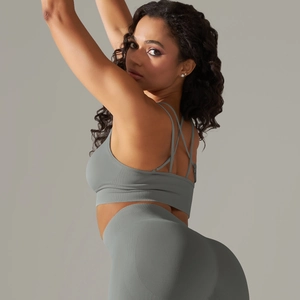 Detail of grey ribbed sports bra with cross-back straps and high-waisted leggings