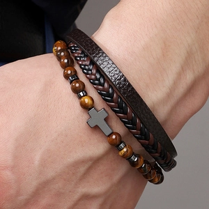Détail d'un ensemble de bracelets multicouches en cuir avec perles oeil de tigre et croix
