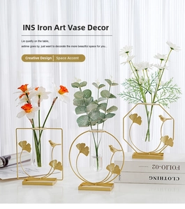 Detailed view of geometric gold metal frame vases with glass tubes and ginkgo leaf motifs