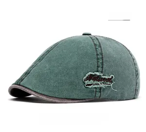 Detail of green washed denim flat cap featuring vintage Natural embroidery patch