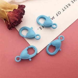 Detail view of four blue heart-shaped plastic lobster clasps for DIY jewelry making