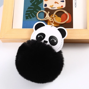 Close-up of panda keychain with white leather head and large black plush ball charm