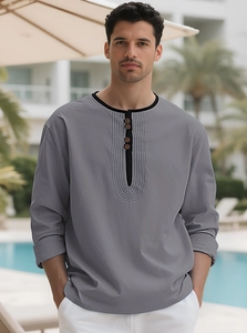Detail of grey linen Henley shirt with black contrast collar in resort setting