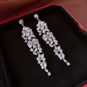 Close-up of elegant flower tassel earrings with crystals on a black velvet lining