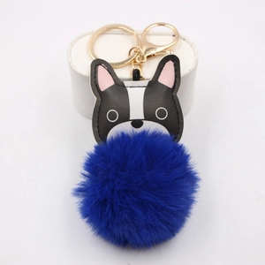 Macro detail of bulldog plush keychain featuring a golden metal clip and deep blue faux fur