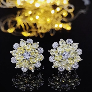 Macro shot of silver stud earrings featuring purple and yellow zircon floral petals