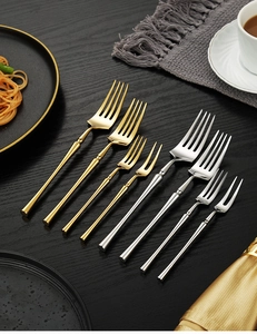 Macro detail of 304 stainless steel gold and silver forks with bamboo-style handles