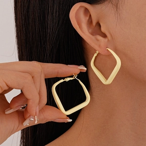 Close-up of model wearing light yellow matte geometric square hoop earrings for women
