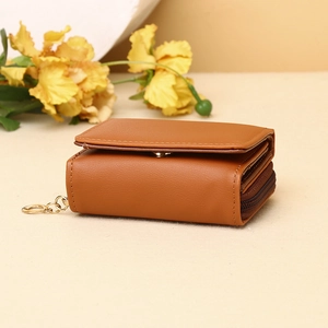 Detail view of brown leather wallet texture with snap closure and side zipper pocket