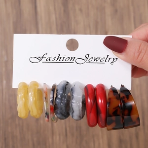 Cinq paires de boucles d'oreilles créoles en résine acrylique colorée sur carte