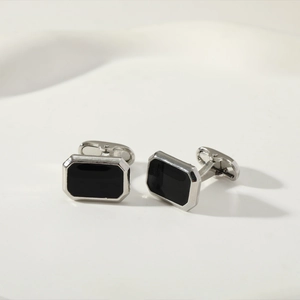 Macro shot of silver rectangular cufflinks featuring polished black enamel inlay for men