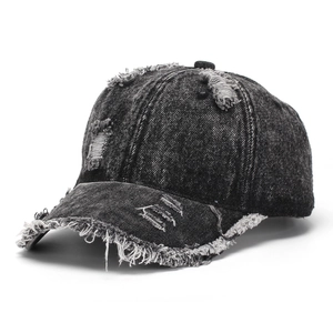 Close-up of distressed vintage grey washed denim baseball cap with frayed brim details