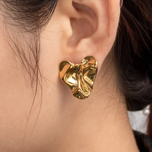 Luxury gold pleated heart geometric earrings in stainless steel on a model