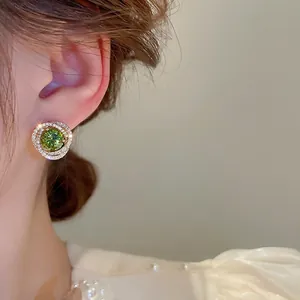 Elegant silver earrings with green zircon center and sparkling swirl diamond pattern