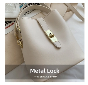 Detail of elegant gold hardware clasp and lychee pattern leather on beige bucket bag