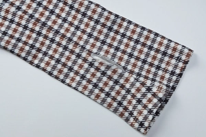 Détail du poignet à motif à carreaux avec trou pour le pouce et texture tissée