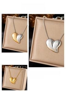 Detailed view of polished heart pendants on snake chains in gold and silver finishes
