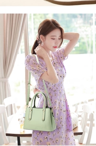 Close-up of light green lychee texture leather tote bag with elegant gold metal accents