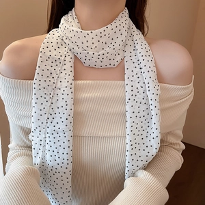 Elegant white skinny scarf with black polka dots styled on a chic beige knit top