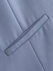 Détail de veste de costume bleu lavande avec poche passepoilée et texture sergée