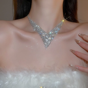 Close-up of sparkling silver V-shaped fringe necklace with pavé rhinestones on model